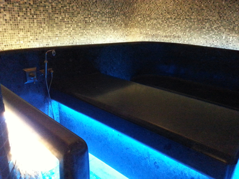 bagno turco in marmo Hammam con panche e lettino in marmo, pareti e soffitto a volta rivestito di mosaico verde e oro